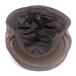 Detail view of the brown leather flat cap showing inner lining and metal buckle closure