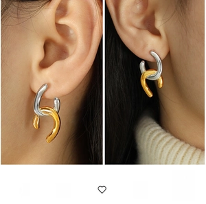 Close-up of interlocking gold and silver geometric hoops on a model wearing a sweater