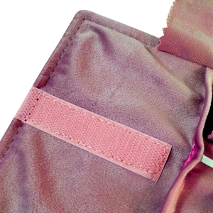 Detail of purple velvet jewelry storage roll featuring pink hook and loop strap