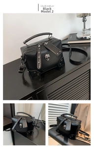 Close-up of black punk crossbody bag featuring silver skull and rivet details