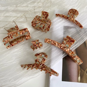 Chic tortoiseshell acetate hair claw clips set in brown and blue marble patterns