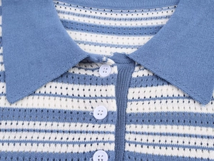 Detail of blue and white striped knit polo shirt with delicate openwork pattern and buttons