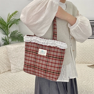 Detailed shot of retro plaid tote bag featuring white lace trim and happy patch fabric