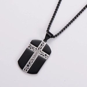 Macro detail of men's black stainless steel necklace with silver cross pendant