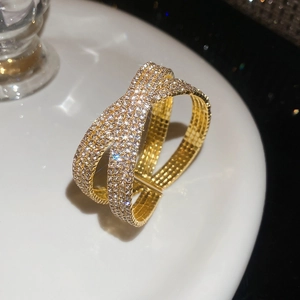 Vue détaillée du bracelet jonc croisé doré avec pavé de cristaux brillants et luxe