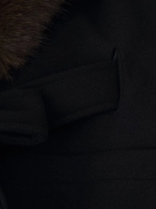 Detail of premium black wool coat showing faux fur collar and waist belt buckle