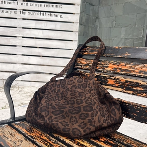 Dettaglio macro della borsa tote leopardata con texture in camoscio e cuciture rinforzate