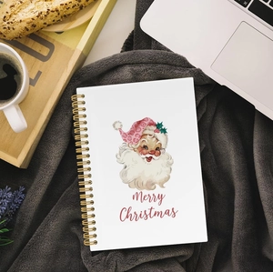 Flat lay of Santa Claus spiral notebook with golden coil on a cozy grey blanket