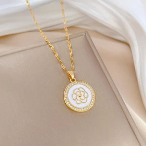 Macro shot of gold camellia flower pendant with sparkling micro-pave crystals