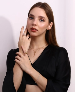 Close-up of 18K gold-plated vertical stripe bow jewelry set worn by a female model