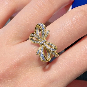 Détail d'une bague nœud étincelante sertie de zircons brillants portée à la main