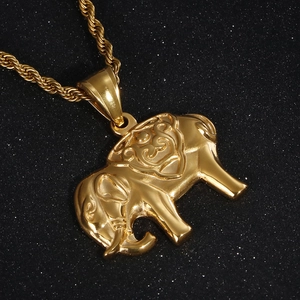 Gros plan d'un pendentif éléphant doré en 3D avec une chaîne corde sur fond noir brillant