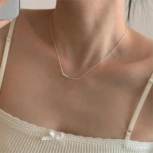 Close-up of minimalist 925 silver bow necklace on model with elegant thin chain detail