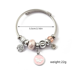 Detail of silver charm bracelet with pink butterfly, tree of life, and size markings