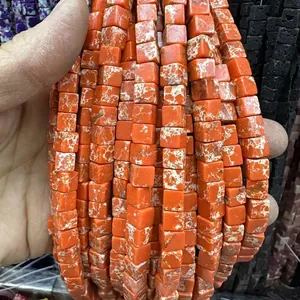 Vue macro de perles carrées en pierre naturelle orange avec texture marbrée pour bijoux