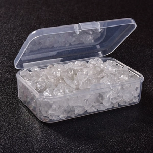 Macro detail of white quartz crystal chips in a clear rectangular plastic storage box