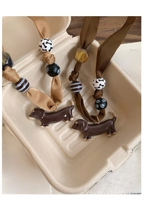 Detailed view of handmade dachshund fabric pendants in vintage style packaging box