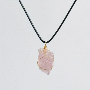 Detailed view of irregular pink quartz pendant wrapped in golden wire on black cord