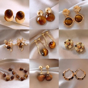Detailed grid of nine vintage gold earrings with tiger eye stones and pearls