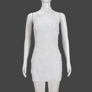 Détail d'une mini-robe en dentelle blanche avec appliques de roses 3D et col licou