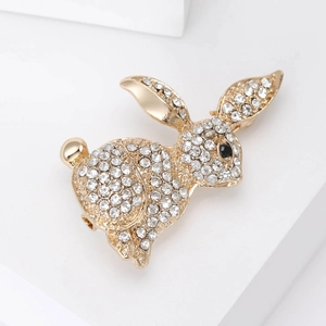 Close-up of golden rabbit brooch with sparkling rhinestones and black crystal eye detail