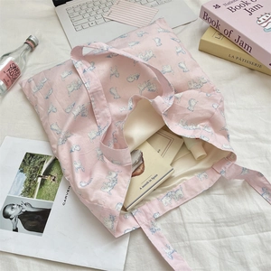 Pink canvas tote bag with cat print showing large capacity for books and skincare