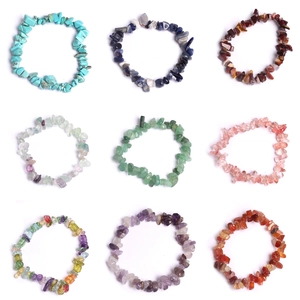 Multiple rows of natural crushed crystal bracelets in various vibrant colors on white background