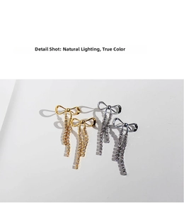 Detailed close-up of bow knot tassel earrings with sparkling rhinestones in gold and silver