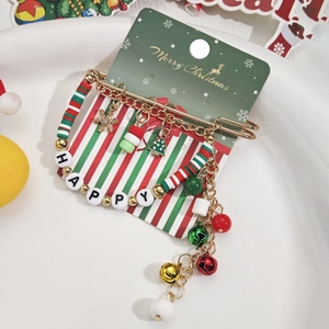Détail d'une broche de Noël avec perles rouges et vertes, chaînes et breloques flocon