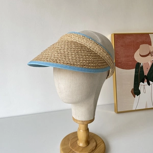 Détail d'une visière en paille de raphia avec bordure en tissu bleu clair pour l'été
