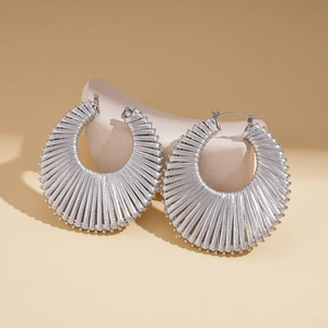 Detailed macro view of silver geometric woven hoop earrings with textured metal surface