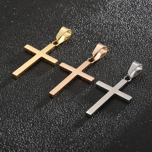 Vue détaillée de pendentifs croix en acier titane en finitions or, or rose et argent