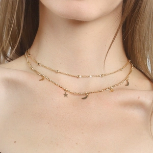 Double-layered gold necklace with star and moon pendants on a dainty bead chain