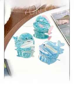 Detailed view of three marble texture acetate shark hair claws on a mirror surface
