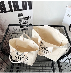 Set of two off-white canvas tote bags with Book Shop print in a wire basket
