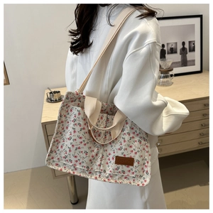 Floral canvas tote bag in cream and pink showing the shoulder strap and texture detail