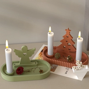 Close-up of matte resin candle holders with oval ripple trays and festive inserts