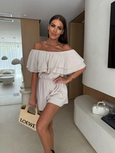 Detail of ruffled off-shoulder neckline and textured fabric on beige summer romper