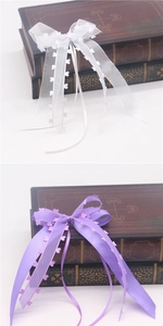 Detail of white and purple heart-patterned organza ribbon bows on vintage books