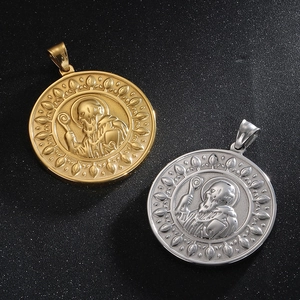 Close-up of gold and silver Saint Benedict medals with detailed religious relief patterns