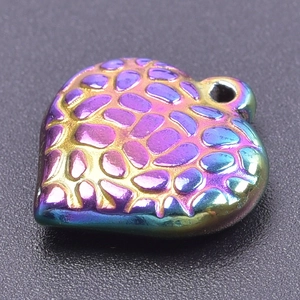 Macro detail of rainbow stainless steel heart charm with 3D honeycomb texture