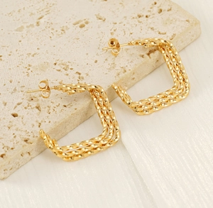 Vue détaillée des boucles d'oreilles carrées en or 18K avec design torsadé chic