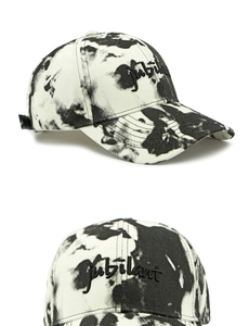 Détail du chapeau de baseball tie-dye avec motif marbré noir et blanc et broderie d'art