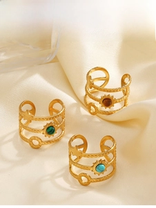 Detailed view of three vintage gold rings with natural stone inlays on satin fabric