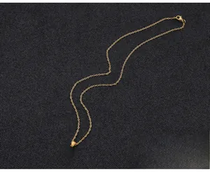 Detail of gold letter R pendant with circular white inlay and fine chain link