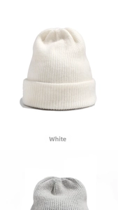Detail shot of the fine ribbed texture and folded cuff on this white knitted beanie hat