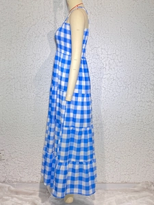 Detail view of tiered blue and white checkered maxi dress with cross straps and backless design