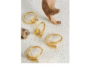 Minimalist gold plated spiral rings shown on rustic stone and wood textures