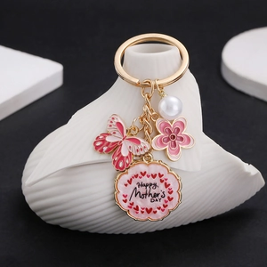 Detail of pink enamel butterfly, flower and pearl charm on Happy Mother's Day keychain