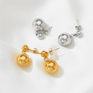 French vintage double gold and silver ball drop earrings on white satin fabric background